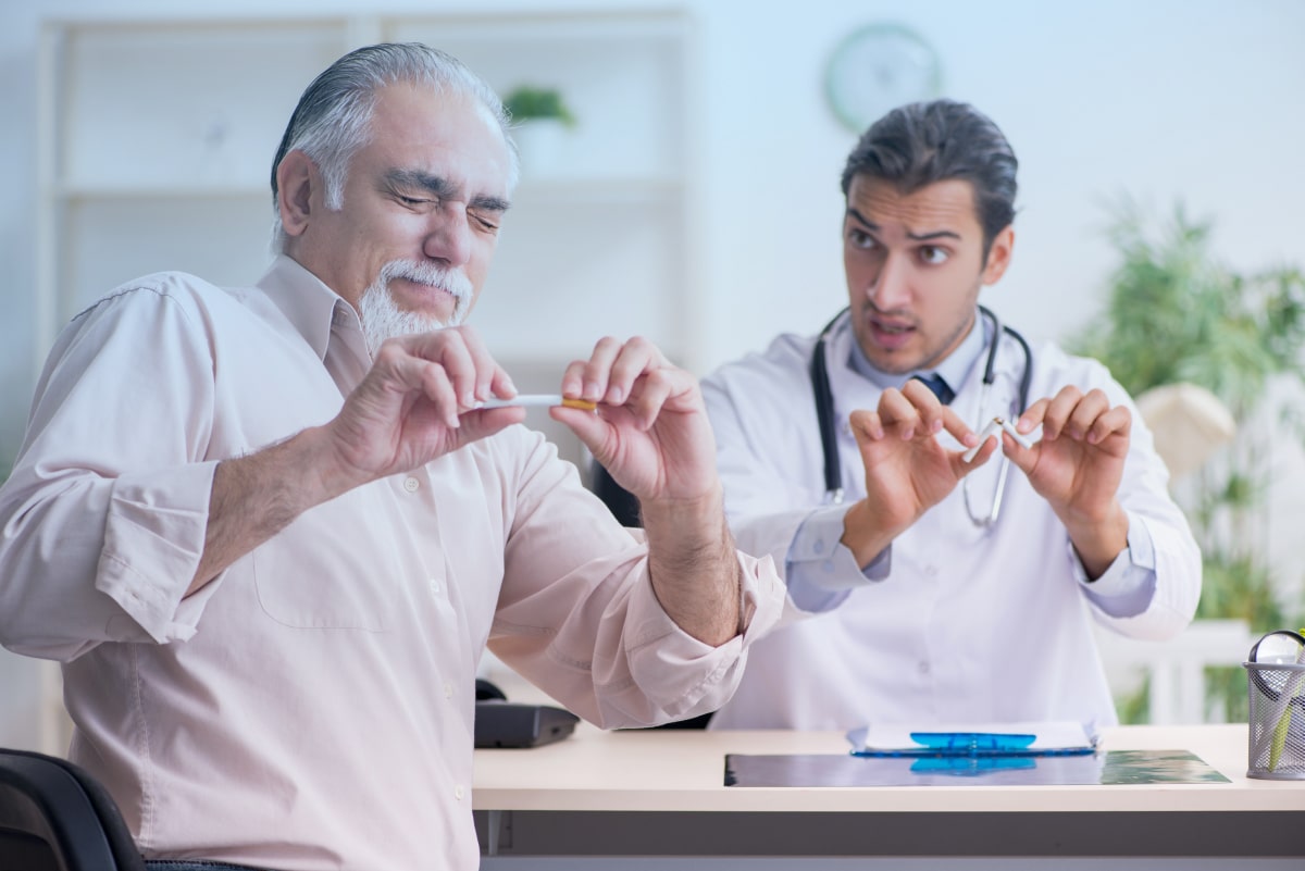 Врач с пациентом ломают сигареты